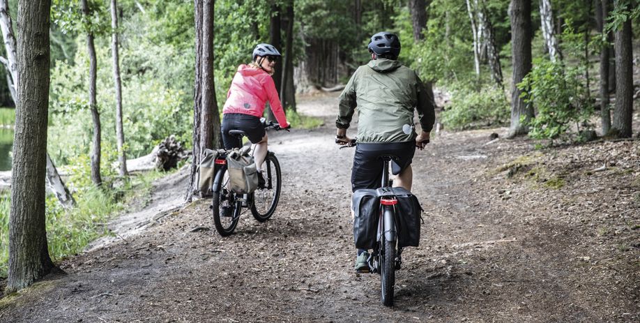 twee fietsers door een bos op elektrische fiets