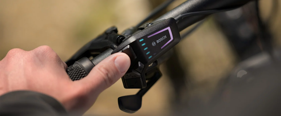 Persoon heeft handvat van stuur vast en bedient met zijn duim de Bosch Led Remote knoppen