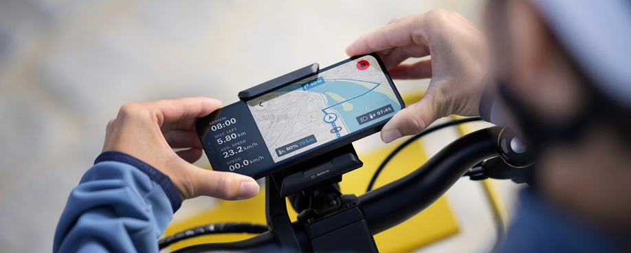 Persoon klem zijn telefoon vast op de Bosch SmartphoneGrip voor een handig scherm voor navigeren
