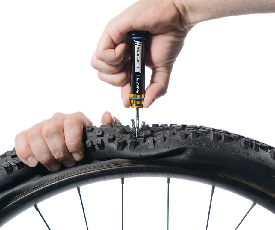 Persoon prikt tubeless buitenband in met een tubeless plug en reparatieset