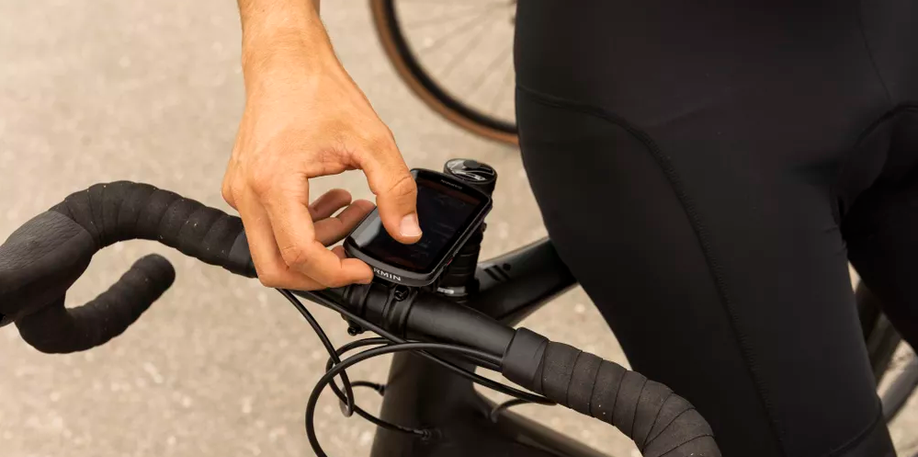 Garmin Edge 1040 op racefiets gemonteerd met persoon die fietscomputer gaat bedienen