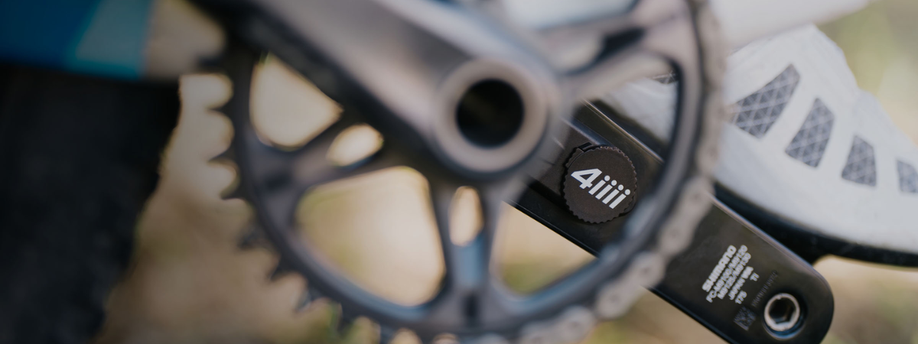 4iiii powermeter in de crankarm met witte schoenen en kettingblad op voorgrond