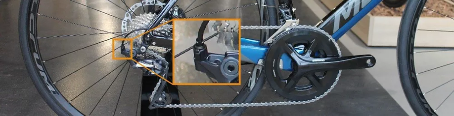 Blauwe Merida racefiets met ingezoomd beeld op de stelnippel van de achterderailleur in de 12GO Biking showroom
