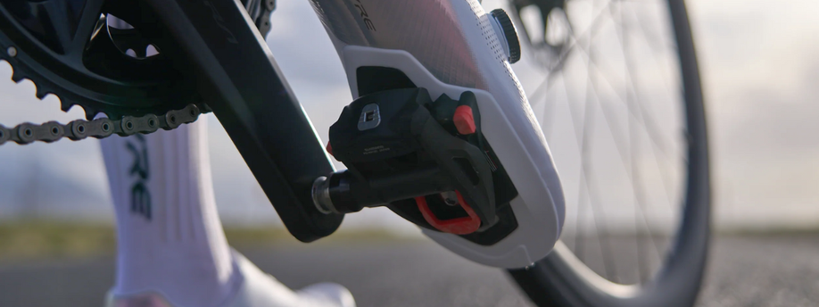 Witte S-Phyre racefietsschoenen ingeklikt met rode SPD-SL pedalen op een racefiets