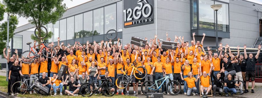 Volledige groep met 12GO Biking personeel voor winkel