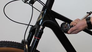 Persoon met vorkpomp in de hand pomp de voorvork op tot de juiste druk