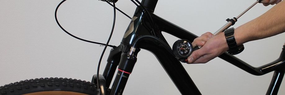 Persoon met vorkpomp in de hand pomp de voorvork op tot de juiste druk