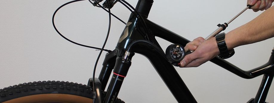 Persoon met vorkpomp in de hand pomp de voorvork op tot de juiste druk