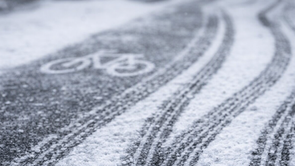 Bandensporen van fietsen op een asfaltweg met sneeuw