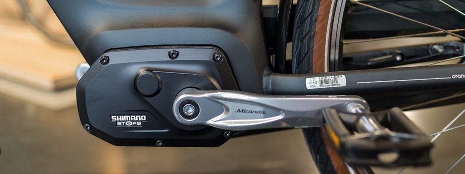 Close-up van de Shimano Steps E6000 motor op een zwarte fiets in de showroom van 12GO Biking
