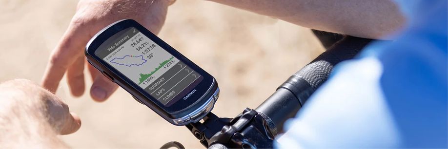 Garmin fietscomputer op stuur gemonteerd met persoon in blauw shirt die op het stuur hangt