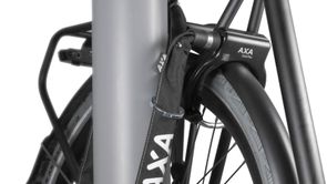 Zwarte fiets met AXA insteekslot is bevestigt aan AXA ringslot en om lantaarnpaal