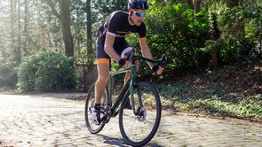 12GO wielrenner met groen racefiets over kasseien