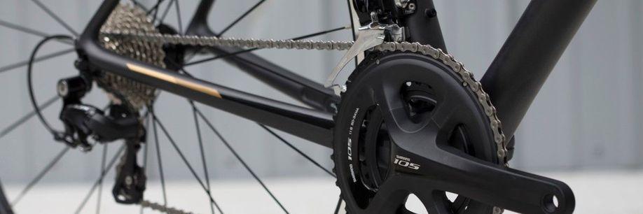 Shimano 105 groepset met voor- en achterderailleur op een zwarte racefiets voor een witte achtergrond