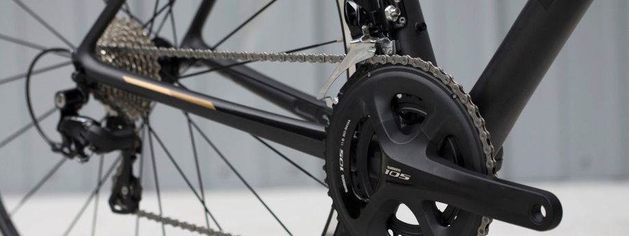 Shimano 105 groepset met voor- en achterderailleur op een zwarte racefiets voor een witte achtergrond
