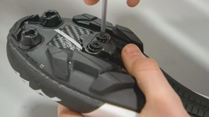 Vastdraaien van de bouten met inbus van een SPD-schoenplaatje onder een mountainbikeschoen