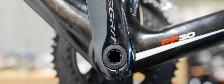 Ultegra crank-as van een zwarte fiets met PF30 logo erop