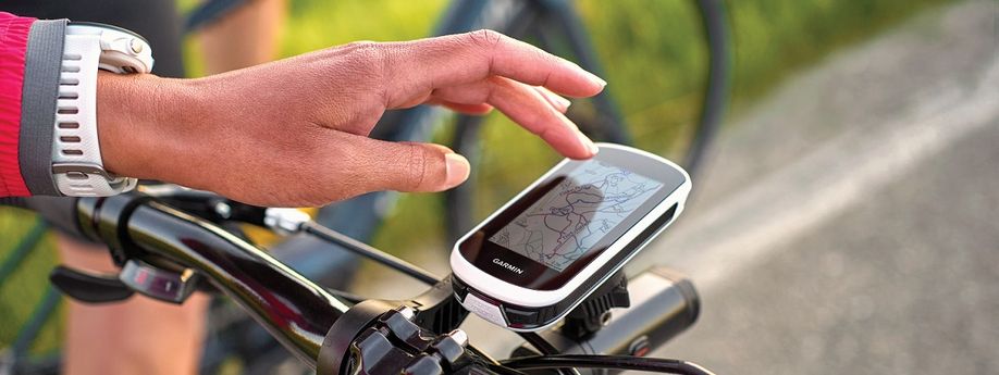Garmin Edge Explore 2 op fiets met Garmin Varia voorlicht eronder en persoon die touchscreen gebruikt