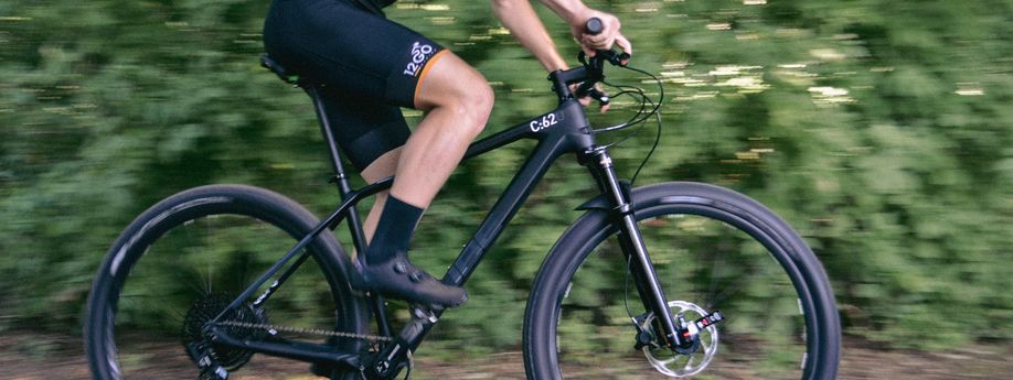 Fietser met 12GO Biking fietskleding op de Cube Reaction C:62 One voor vage bosjes omdat hij aan het fietsen is