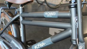 Groene Alpina Cargo kinderfiets met bruin zadel en bruine banden in de showroom van 12GO Biking