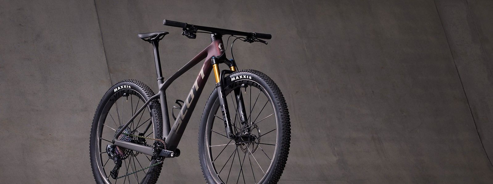 Scott mountainbike met mooie rood zwarte gradient voor betonnen grijze muur
