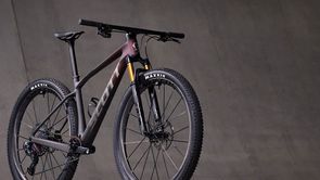 Scott mountainbike met mooie rood zwarte gradient voor betonnen grijze muur
