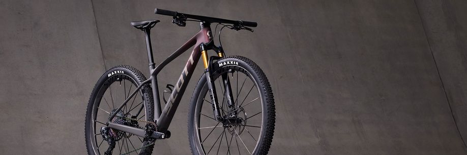 Scott mountainbike met mooie rood zwarte gradient voor betonnen grijze muur