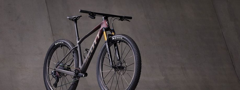 Scott mountainbike met mooie rood zwarte gradient voor betonnen grijze muur
