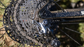 Shimano cassette en achterderailleur op een zwarte mountainbike met Shimano sticker op het frame met gras op de achtergrond
