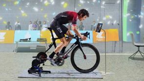 Professionele wielrenner Geraint Thomas op een Pinarello racefiets met Wahoo Kickr V6 en een Zwift in-game achtergrond