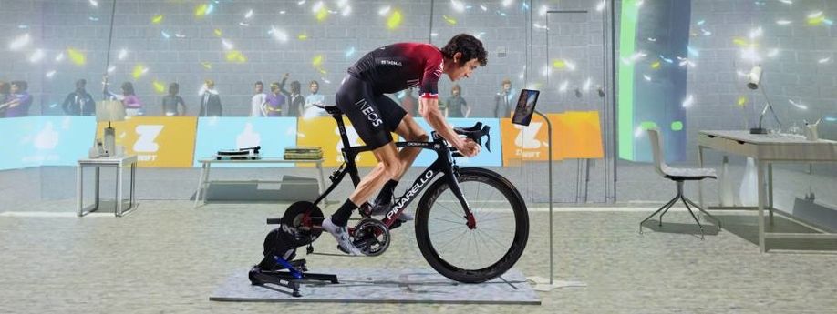 Professionele wielrenner Geraint Thomas op een Pinarello racefiets met Wahoo Kickr V6 en een Zwift in-game achtergrond