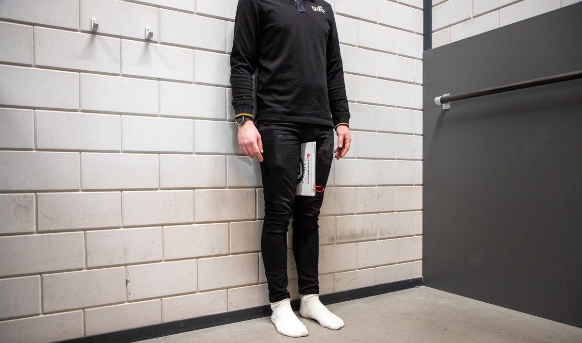 Op sokken recht staand tegen een muur.