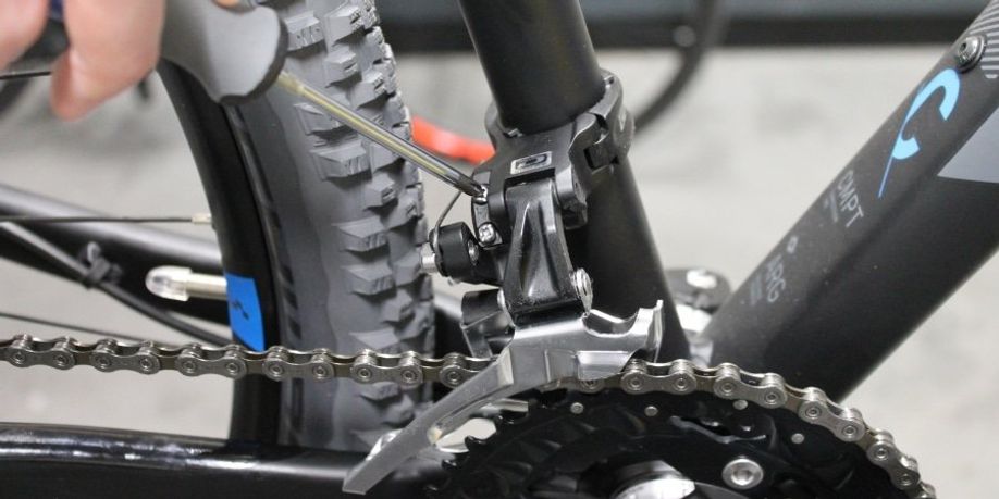 Afstellen van de voorderailleur met een kruiskopschroevendraaier door de L-stelschroef aan de passen op een mountainbike