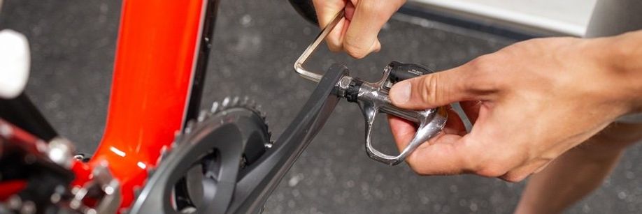 Persoon draait pedaal van een Dura-Ace crank af door gebruik te maken van een inbusstleutel