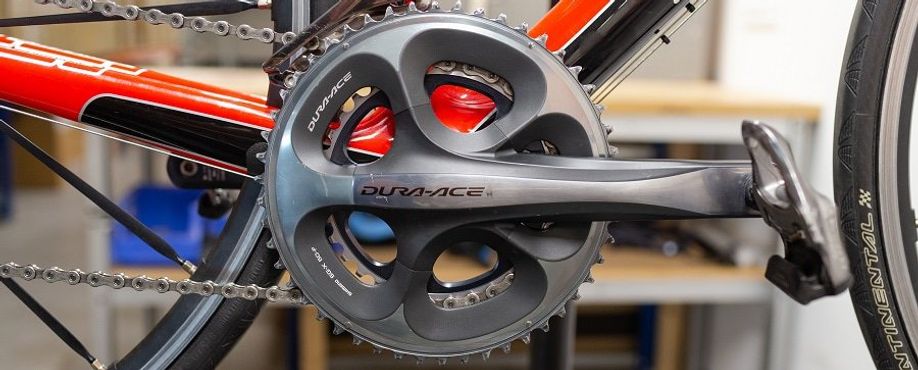 Rood met zwarte racefiets met Dura-Ace crankstel en pedalen
