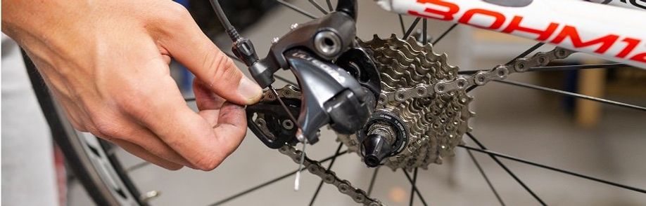 Achterwiel van racefiets wordt losgehaald door de achterderailleur wat te liften