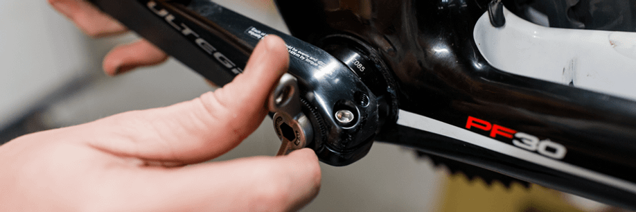 Persoon draait crankdrop weer aan nadat de borgpin eerst weer op de juiste plek in de crankarm is gezet