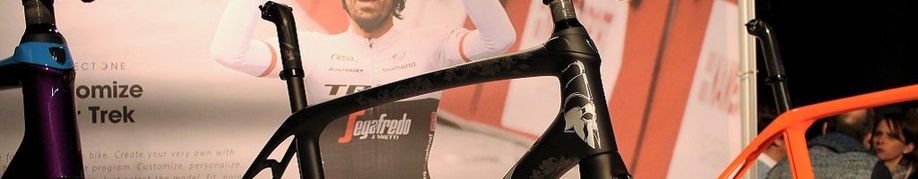 Verschillende balhoofden van racefietsen op een expo van Trek met een banner van de Project One op de achtergrond