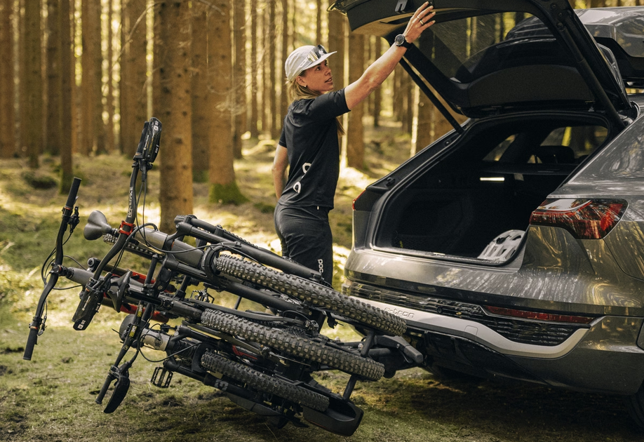 De Thule EasyFold 3 fietsendrager met drie fietsen gemonteerd achterop een auto in het bos