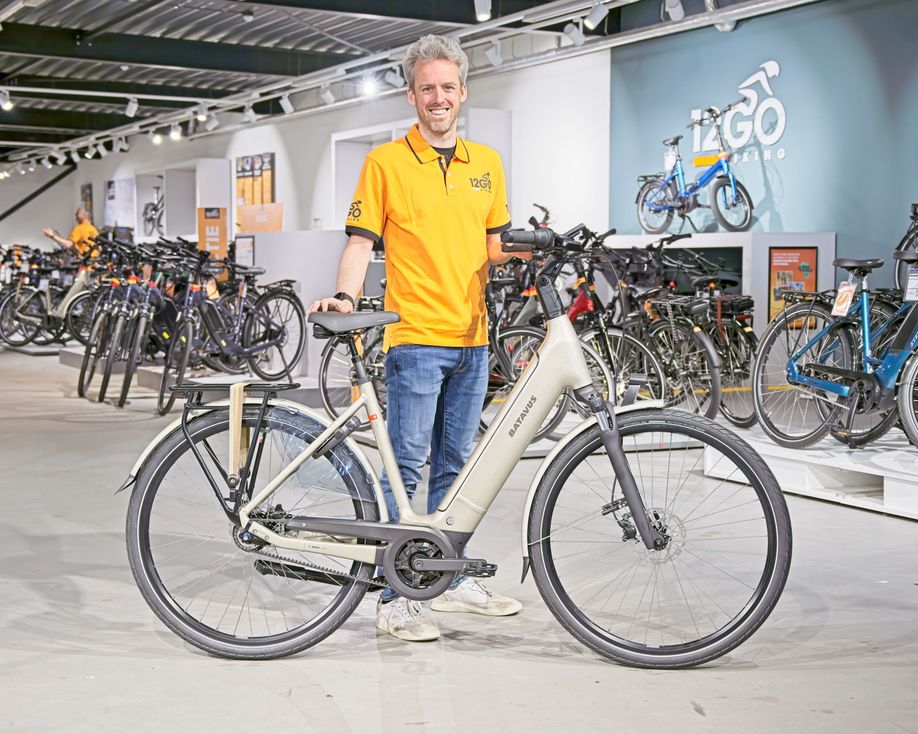 Batavus Finez E-go Power Exclusive Smart in de handen van een medewerker van 12GO Biking in de winkel