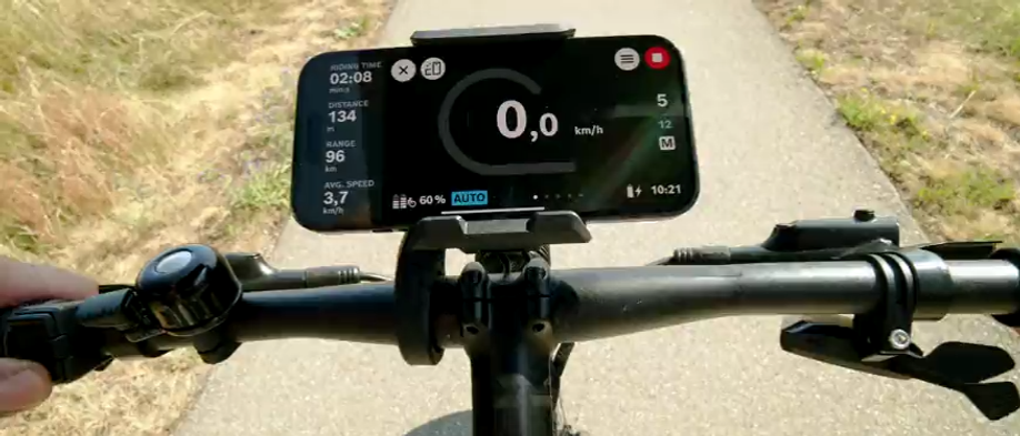 Telefoon met ritgegevens in de Bosch SmartphoneGrip op een smal geasfalteerd fietspaadje
