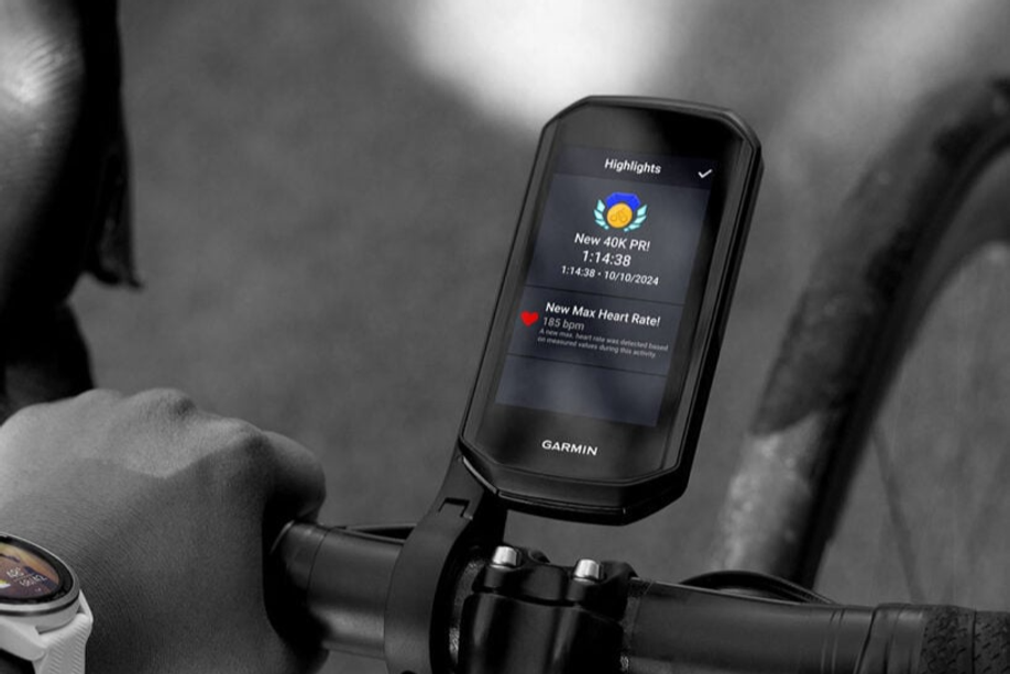 Garmin Edge 1050 met hoogtepuntenscherm van een PR en maximale hartslag op een houder van een racefietsstuur