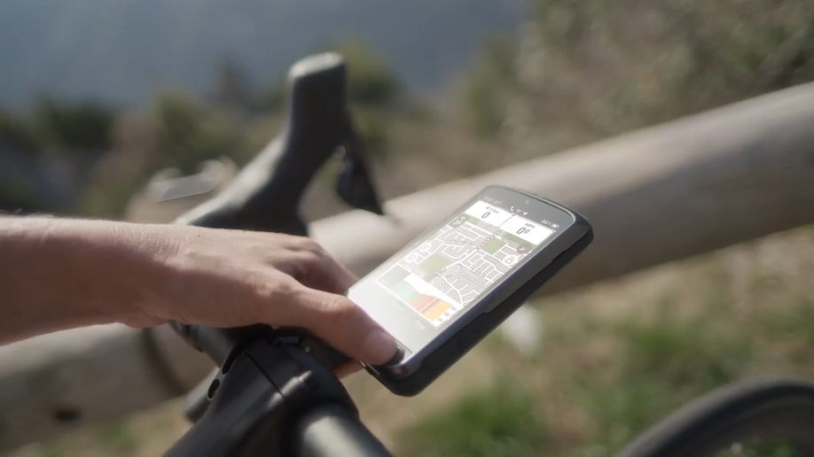 Wahoo Elemnt Ace wordt bediend met knoppen onder fel zonlicht in de reflectie van het scherm