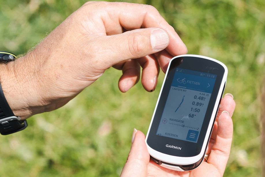 Persoon houdt Garmin Edge Explore 2 vast met fietsen scherm en ander persoon gaat aantikken